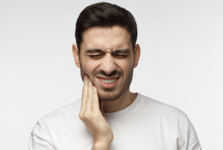 man in pain touching his right cheek